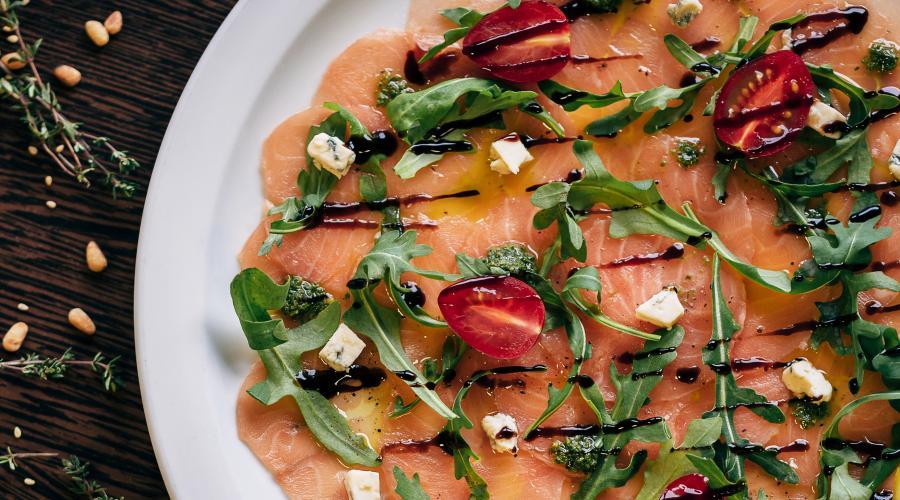 Zu sehen ist das Beitragsbild zum Thema: Lachs-Carpaccio mit Rucola und Tomaten in der Auflösung 900x500